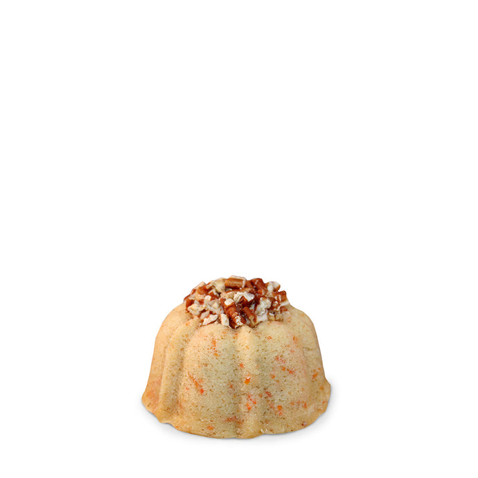 Carrot and cinnamon pound cake in the shape of a bundt filled with cinnamon cream cheese buttercream and topped with toasted pecans. serves 1-2. Each Janie's Cake Petite size pound cake is packaged in a clear container with a Janie's logo sticker and yellow and white striped closure sticker.