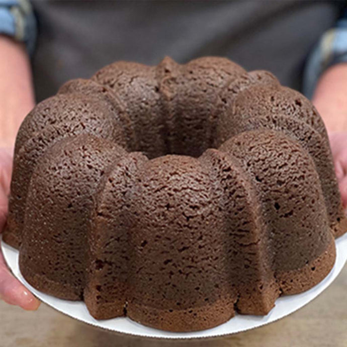 Chocolate TX Bourbon Whiskey Lane Jane pound cake in the shape of a bundt finished off with a whiskey glaze. Serves 12. Packaged in our signature yellow and white striped gift box with a blue bow.