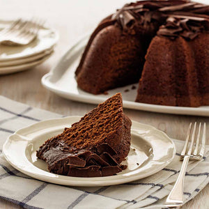 Slice of Chocolate pound cake in the shape of a bundt filled with chocolate sauce and topped with chocolate shavings. Serves 12.