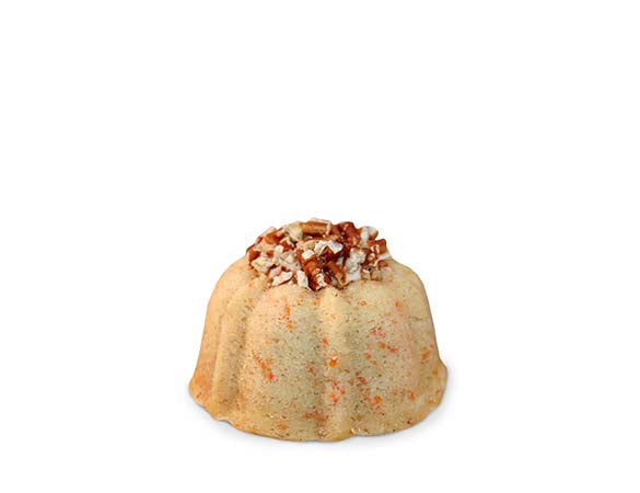 Carrot and cinnamon pound cake in the shape of a bundt filled with cinnamon cream cheese buttercream and topped with toasted pecans. serves 1-2. Each Janie's Cake Petite size pound cake is packaged in a clear container with a Janie's logo sticker and yellow and white striped closure sticker.