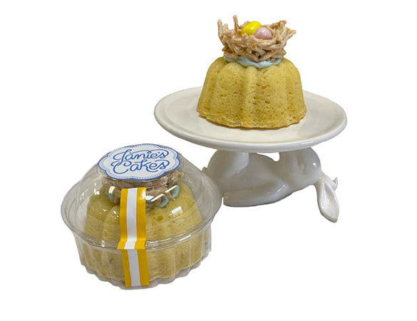 These are eggsquisite Easter Nest Petite Janes!    Vanilla pound cake  filled with an light blue vanilla buttercream  topped with a white chocolate coated chow mein noodle Easter nest  that is garnished with two pastel milk chocolate candy eggs.
